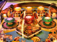 Photo: Old pinball playfield with jet bumpers and period artwork (Western 'cowgirls' theme)